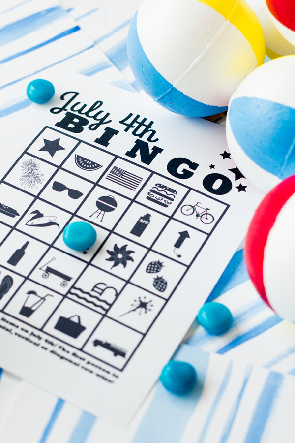 Free Printable 4th of July Bingo 4th of July bingo page on a watercolor background with blue candies on top.