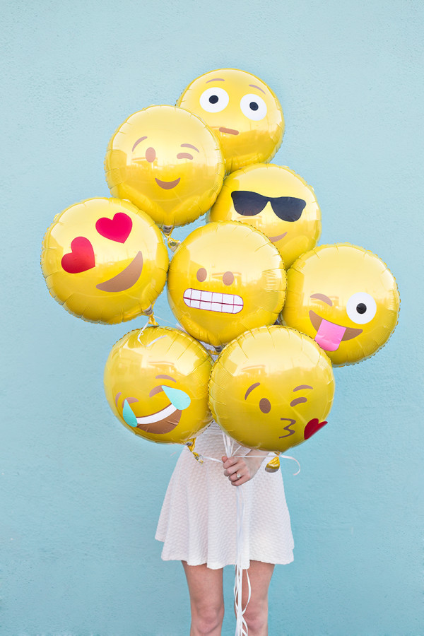emoji balloons being held