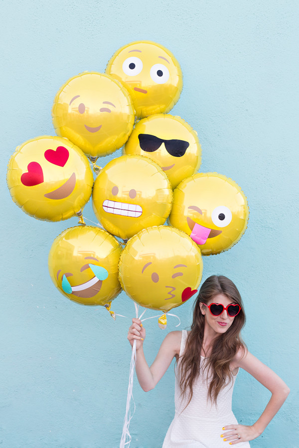 A woman wearing a costume, with Emoji Balloons