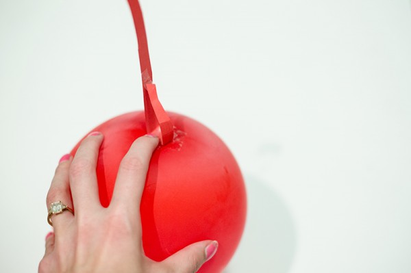 Someone holding a fake cherry 