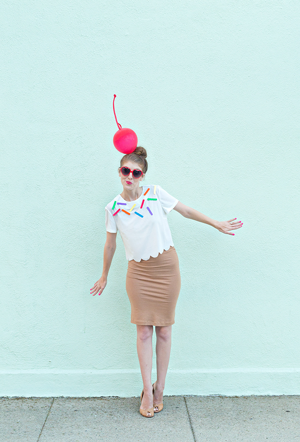 A woman dressed as ice cream in front of a blue wall