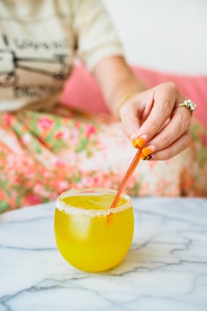 Someone putting a straw in an orange drink