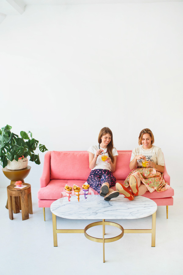 Two people sitting on a couch eating food