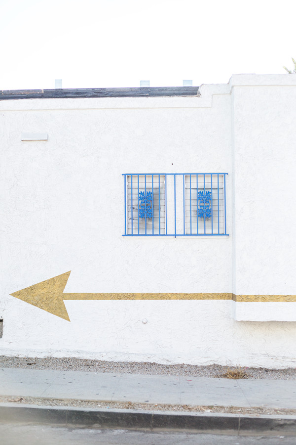 A gold arrow on a white building 