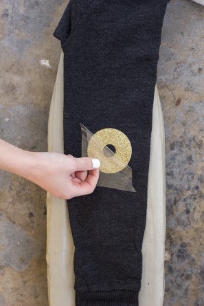 Someone putting a circular gold item on black fabric