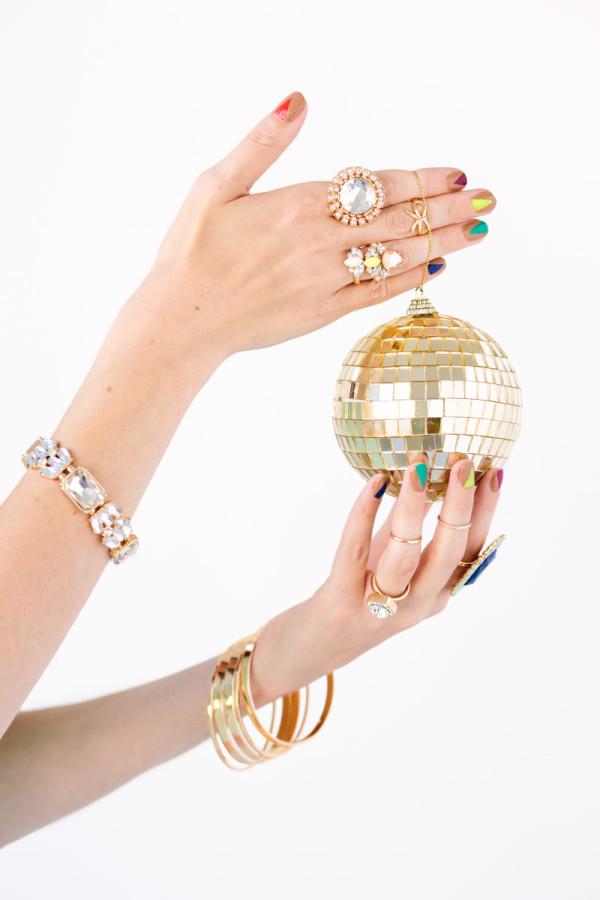 A woman holding a tiny gold disco ball