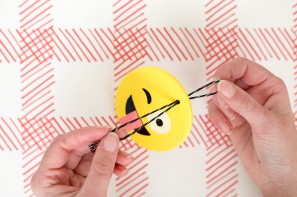 Someone making an emoji ornament 