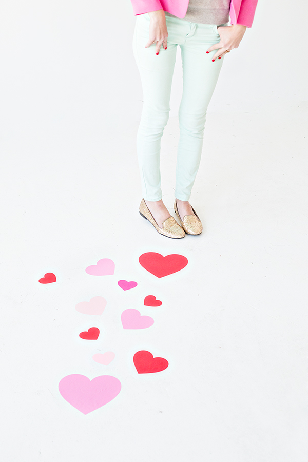 A person standing next to hearts on floors 