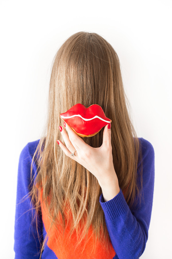 A woman holding a lip donut