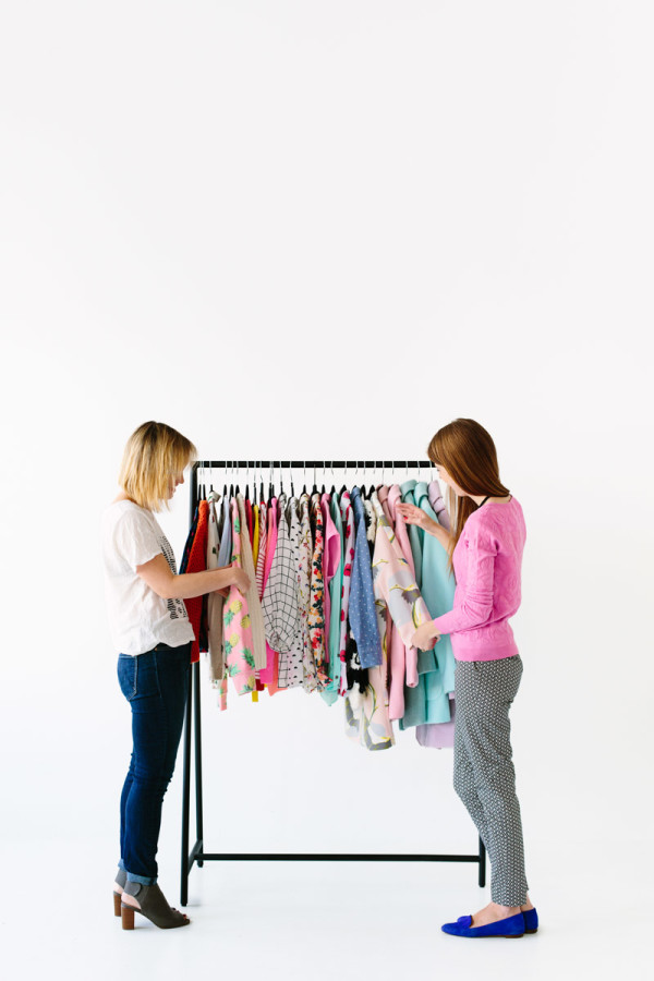 Two women looking at a colorful clothing rack