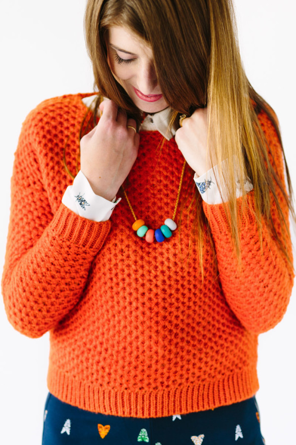 A woman wearing an orange sweater