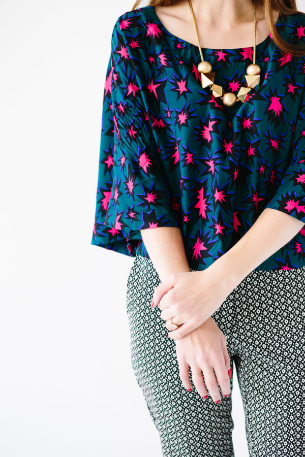 A close up of a woman in a colorful shirt and patterned pants 
