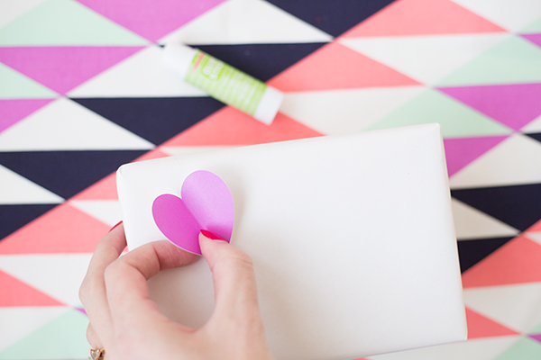 Someone putting a paper heart on a box