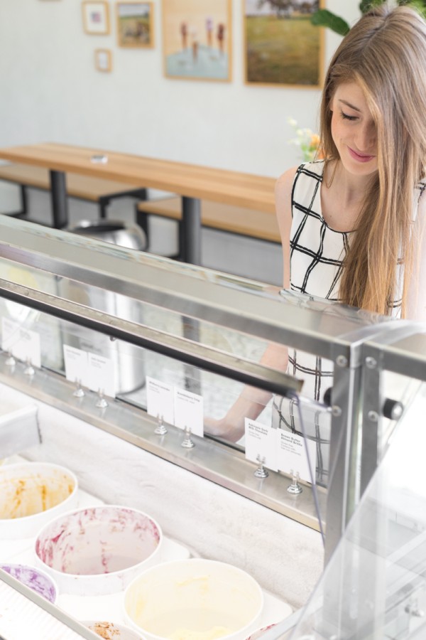 A woman looking at an ice cream freezer 
