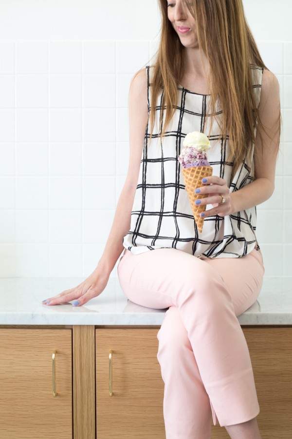 A woman sitting on a bench holding ice cream