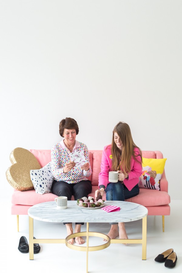 Two people sitting on a pink couch