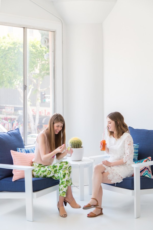 Two girls sitting on blue chairs talking