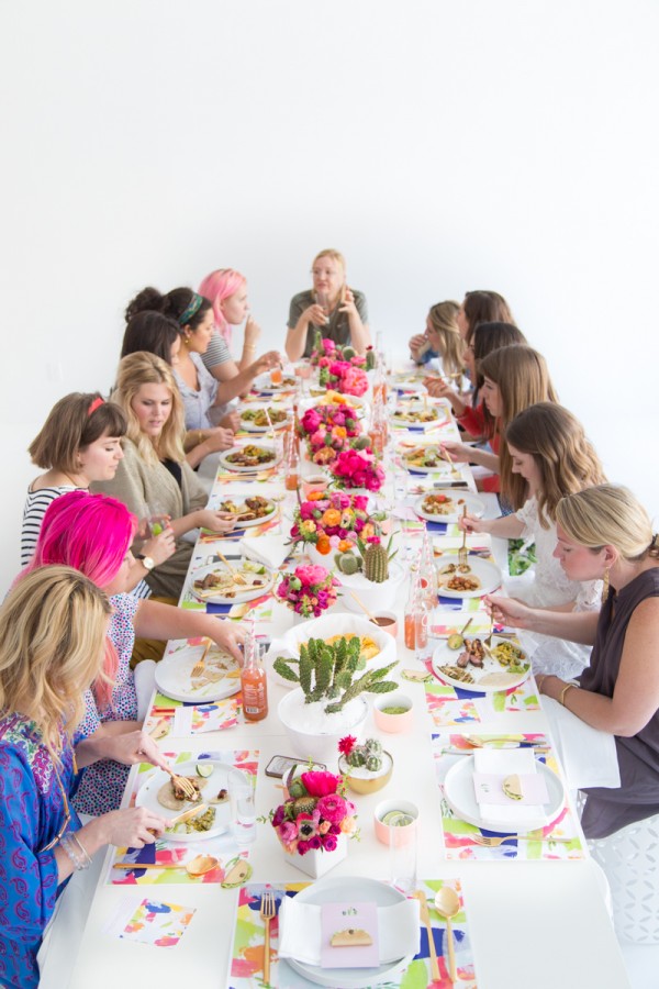 A group of people sitting at a table with a cake