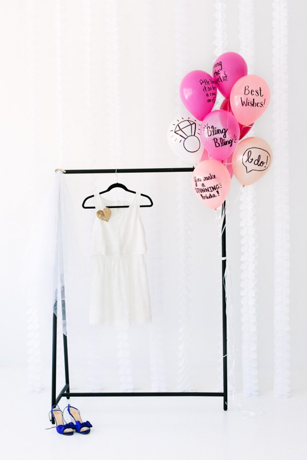 A dressing rack and pink balloons