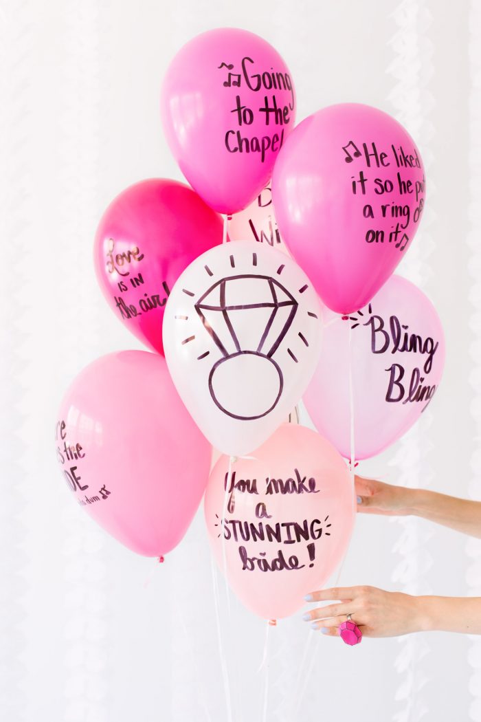 Pink balloons with words on them written in sharpie. 