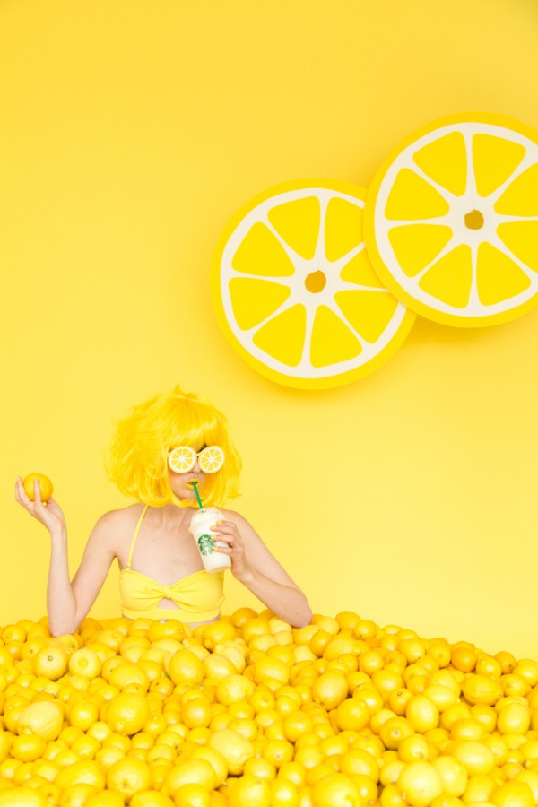 A woman sitting in lemons and drinking a drink