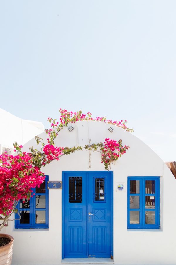 A white building with blue doors and flowers