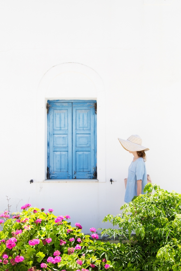 A woman walking past a blue window