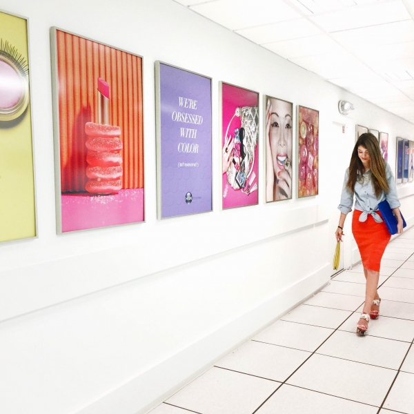 A woman standing next to framed photos