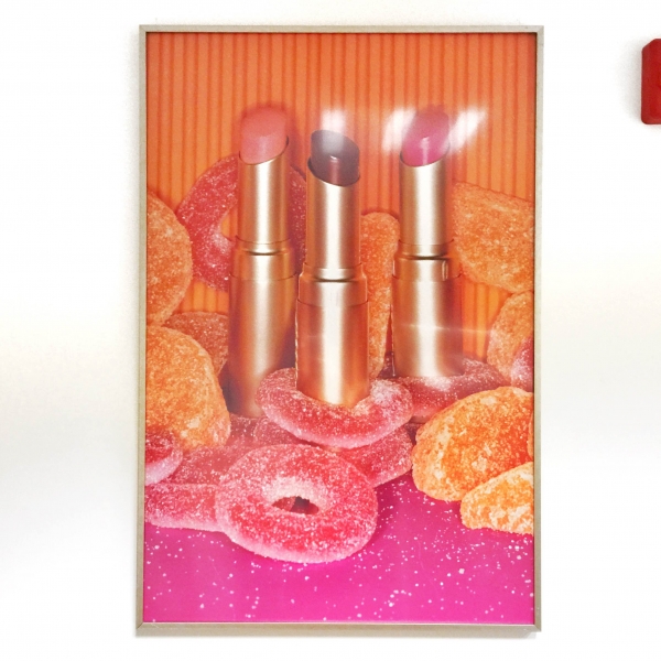 A photo of lipstick and candy in a frame