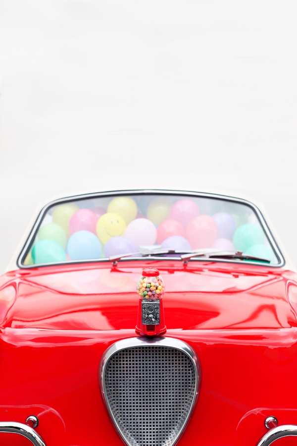 A red car with balloons inside of it