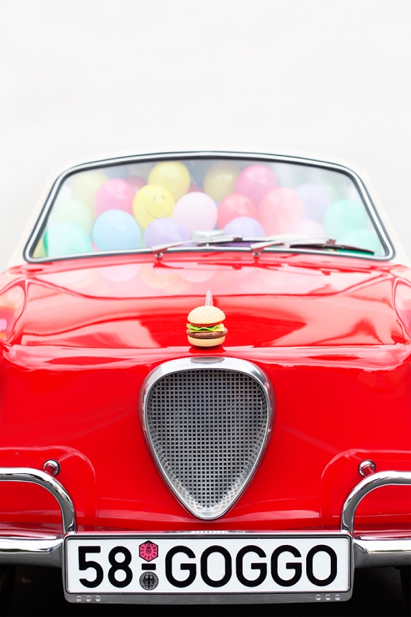 A red car with balloons inside of it