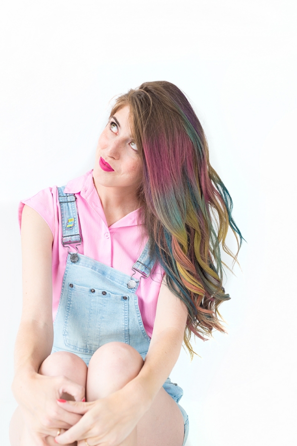 A woman with rainbow hair wearing overalls