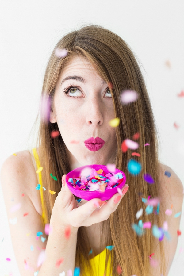 A woman holding a pink tray with confetti