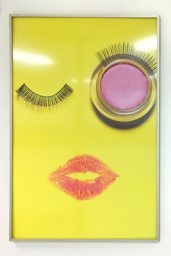 A photo of fake eyelashes and lipstick in a frame