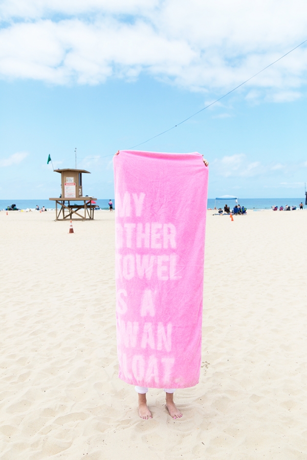 Someone holding a pink towel with words on it