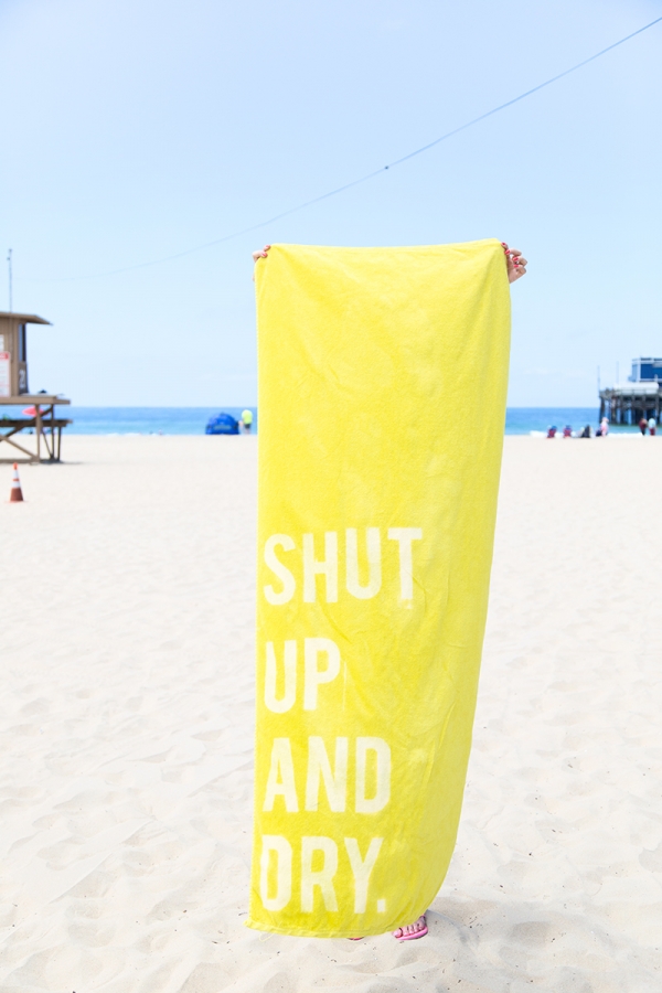 Someone holding a yellow towel that says \"shut up and\"