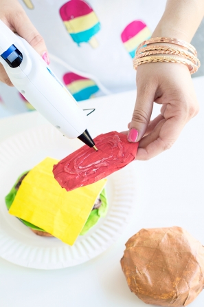 Someone gluing a paper mache burger