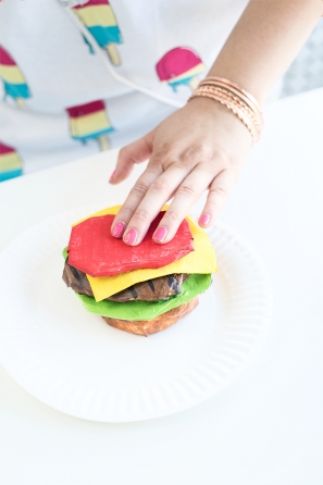 Someone holding a paper mache burger