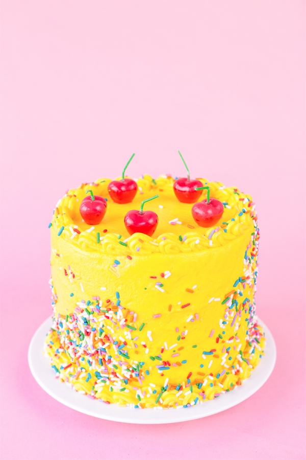 Yellow cake with red cherries on it