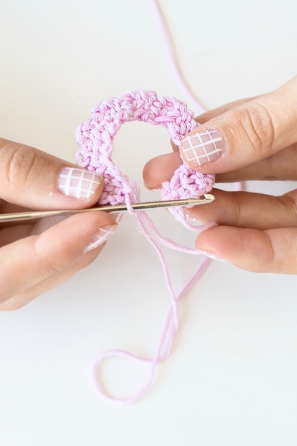 Someone knitting a pink ring