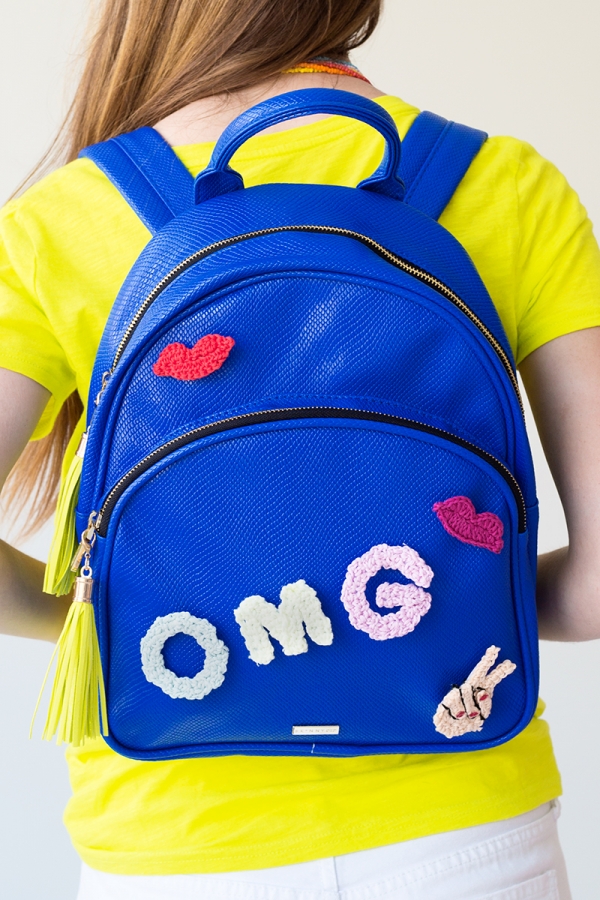 Someone wearing a blue backpack that says \"omg\"
