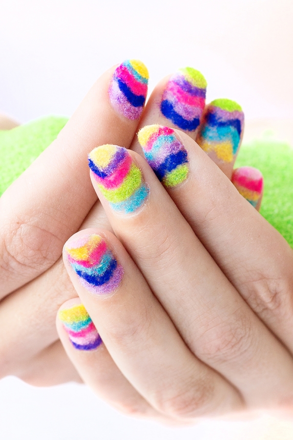 Hands with rainbow powder nails