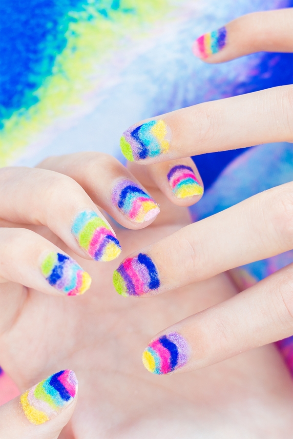 Hands with rainbow powder nails 