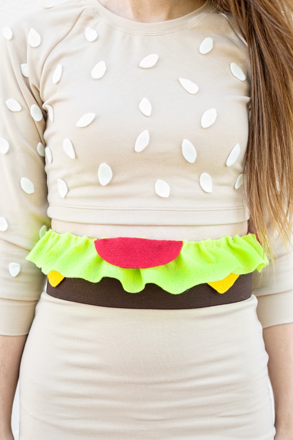 A close up of a woman in a burger costume 