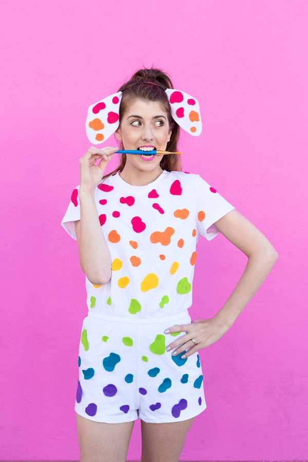 A woman wearing a white outfit with rainbow dots on it