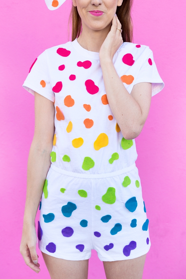 A woman wearing a white outfit with rainbow dots on it