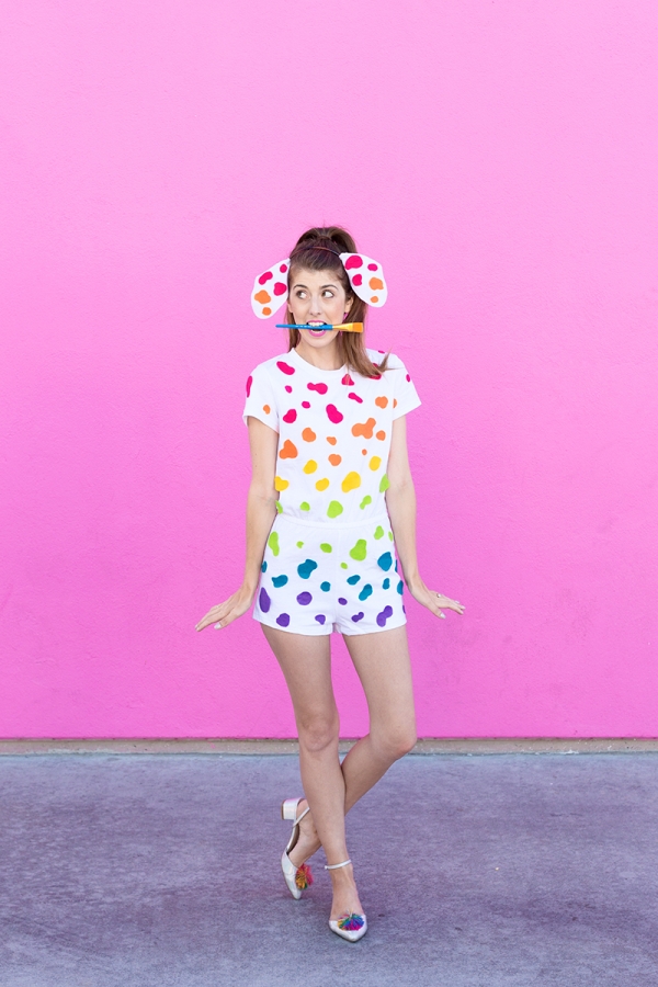 A woman wearing a white outfit with rainbow dots on it