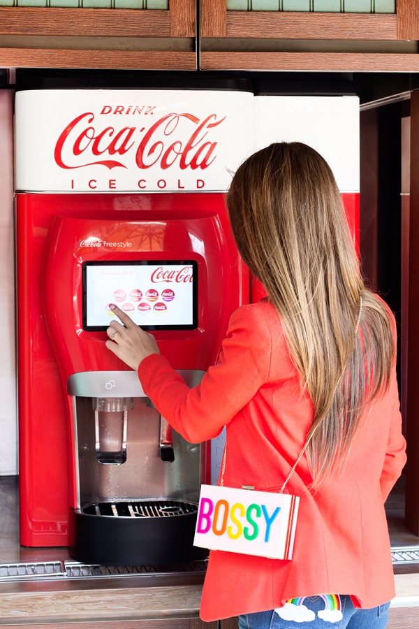 A woman ordering a drink from a machine 