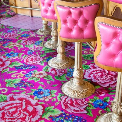 A close up of pink chairs and a pink rug