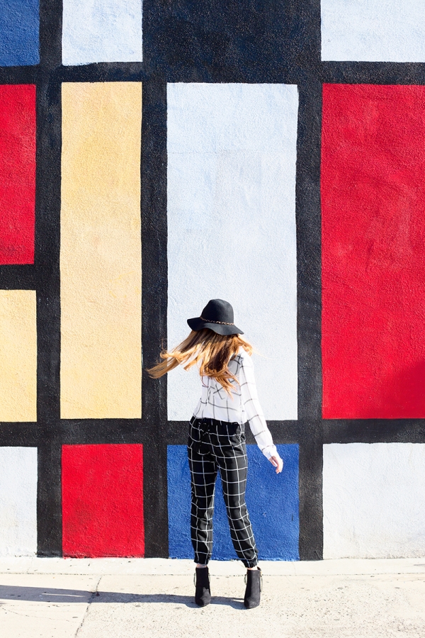 A woman standing in front of a colorful wall